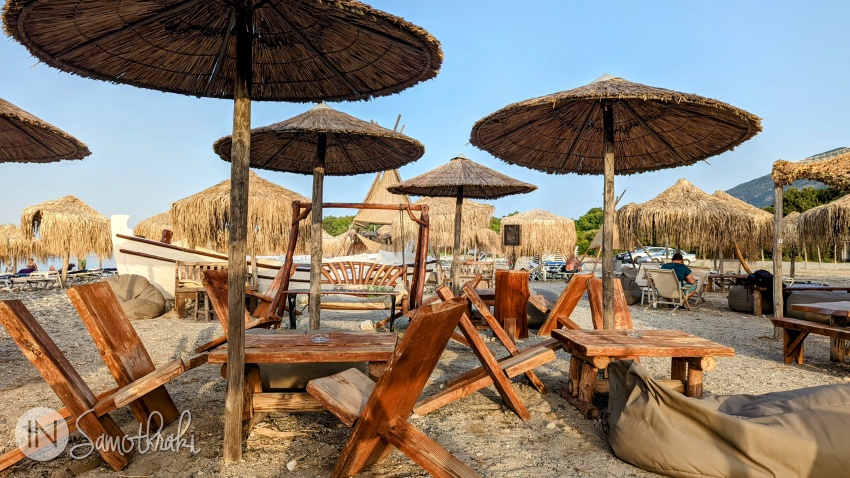 Umbreluțe din stuf și mobilier din lemn pe plaja din Therma